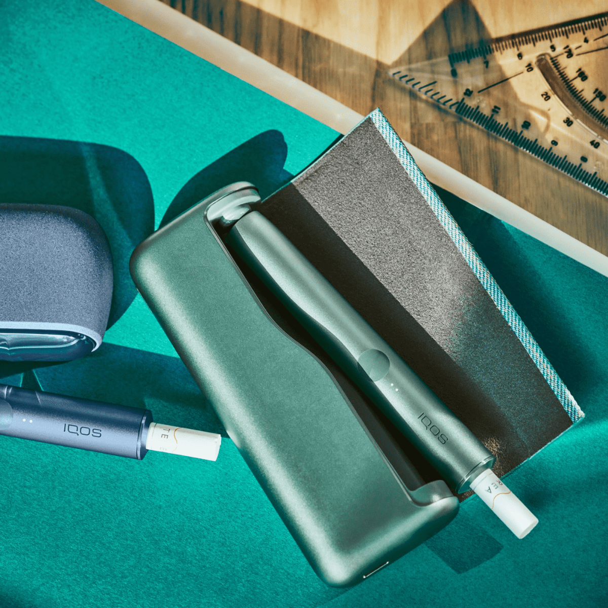 IQOS ILUMA PRIME in Jade Green liegt neben IQOS ILUMA Azure Blue
